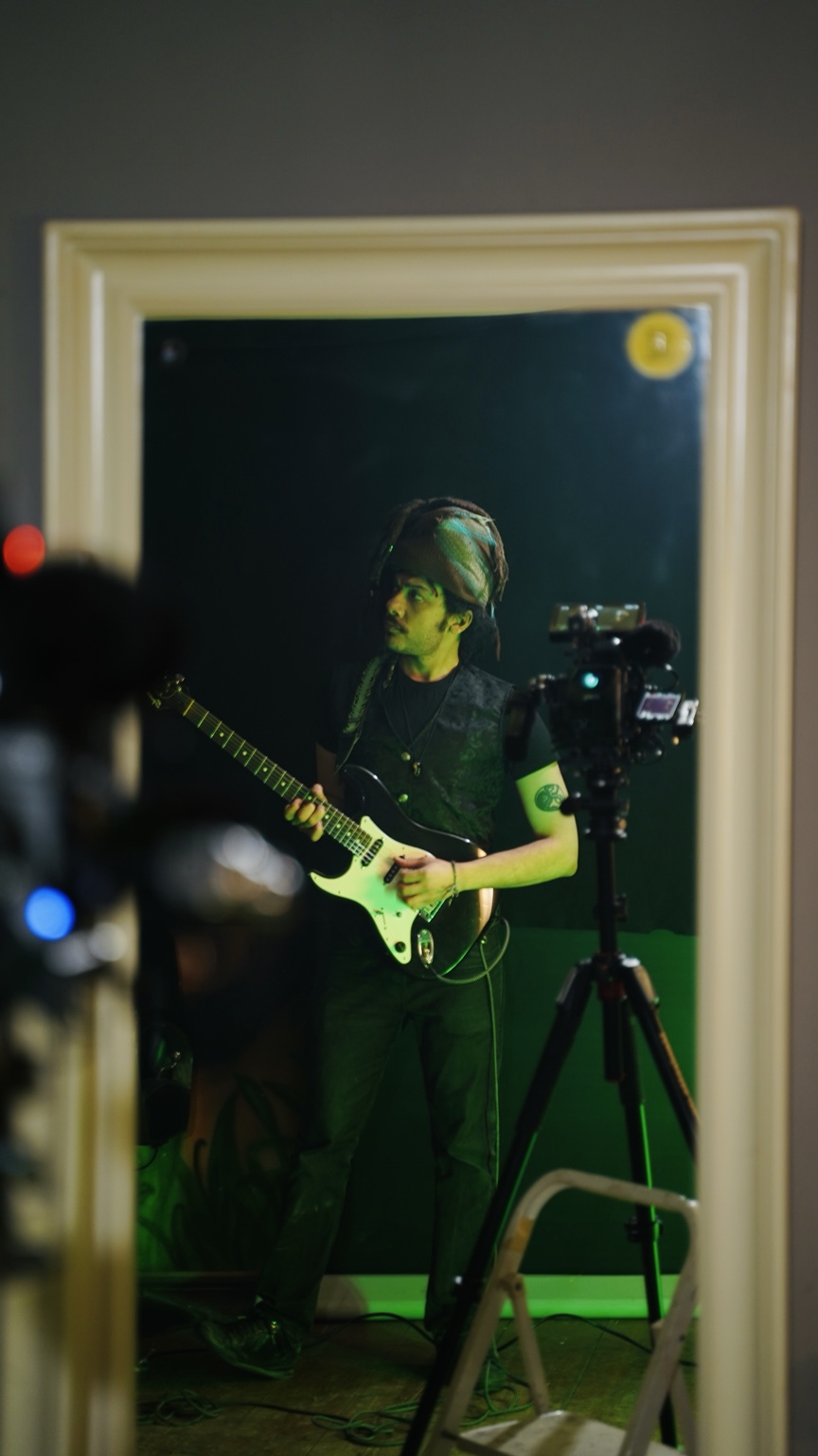 Sammer Salah with guitar reflected in a studio mirror